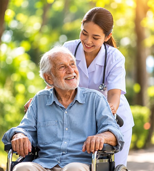 Caregiver accompanying an elderly wheelchair user outdoors